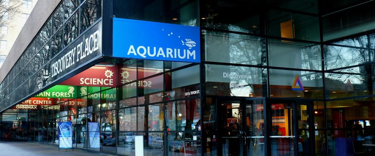 Street-level entrance of Discovery Place Science in Uptown Charlotte, with Aquarium and Science signage