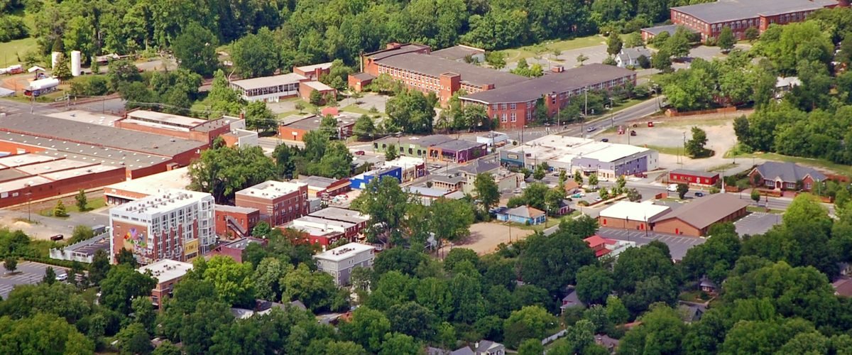 Aerial view of the NoDa arts district in Charlotte, showing its low-rise mill buildings and mural-covered storefronts